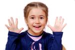 child holding all ten fingers up, representing her understanding of body awareness